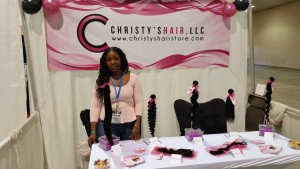 Trade show booth for Christy's Hair showing the Banner, Pink Fabric Bags, Business cards and Postcards designed by HairPackaging.com