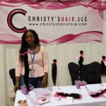 Booth for Christy's Hair showing the Banner, Pink Fabric Bags, Business cards and Postcards designed by HairPackaging.com
